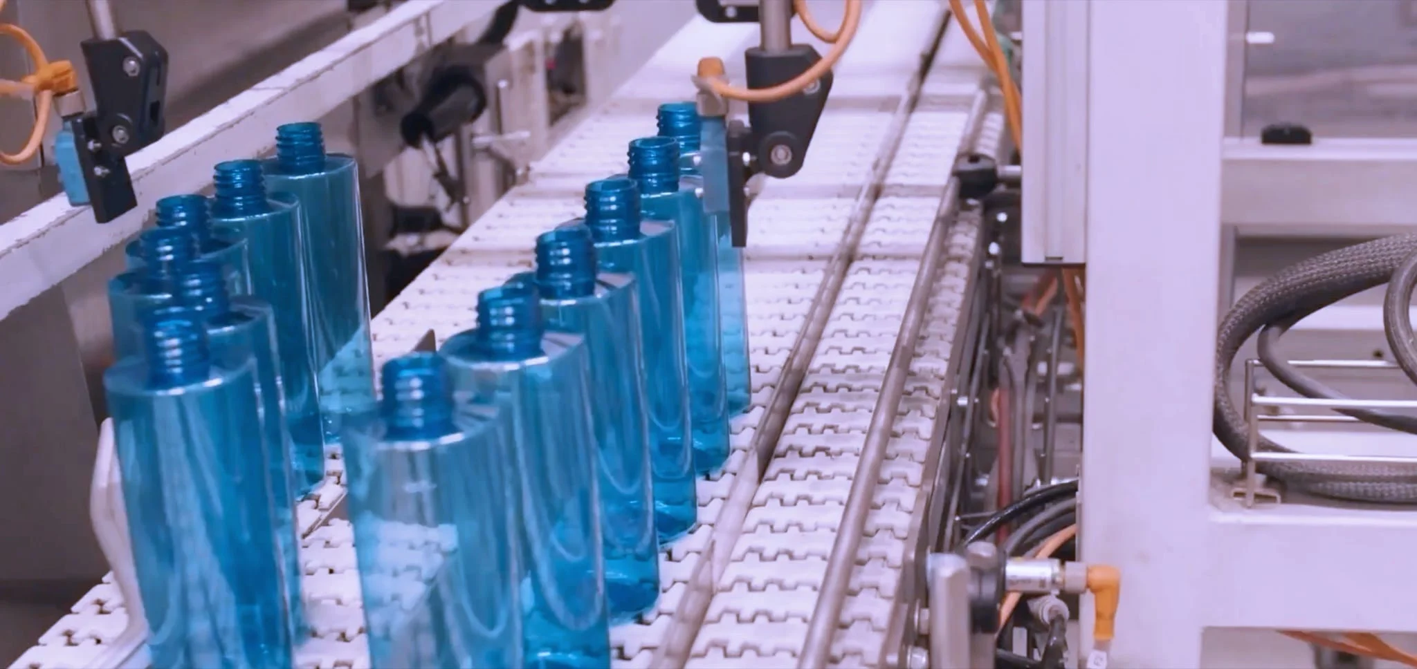 Blue bottles moving along a production line at Axium Packaging