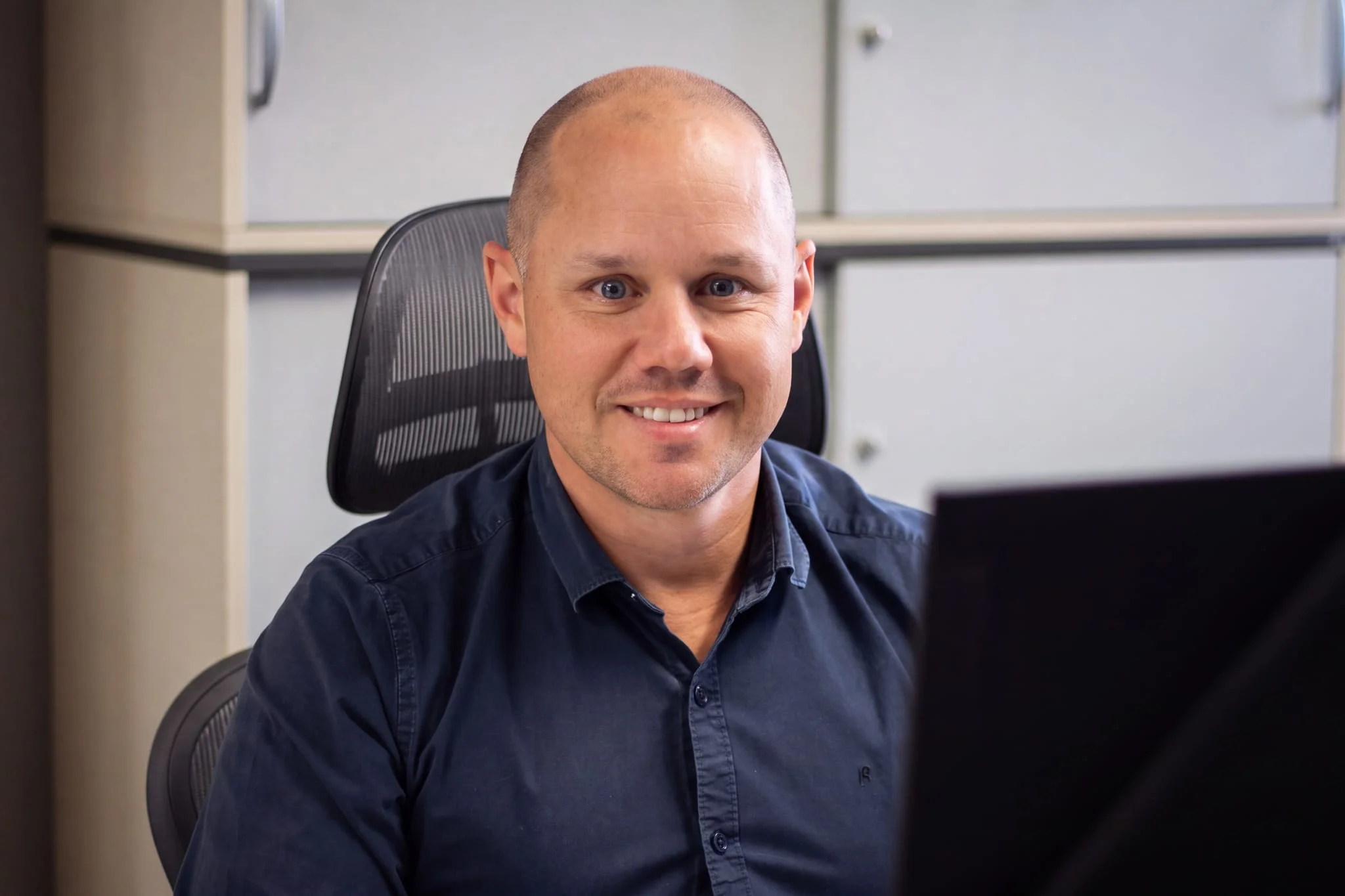 A smiling member of the CompuTec team at their desk in the office