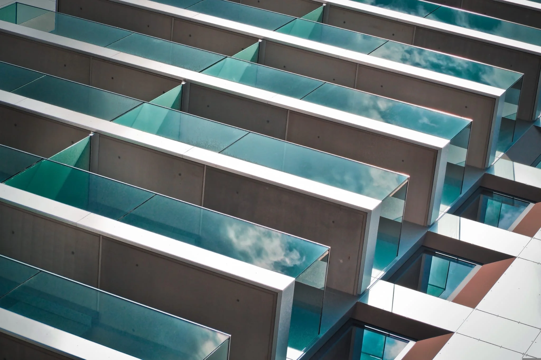 An aerial view of a high-rise building fitted with Copal's aluminum-framed glass balcony enclosures
