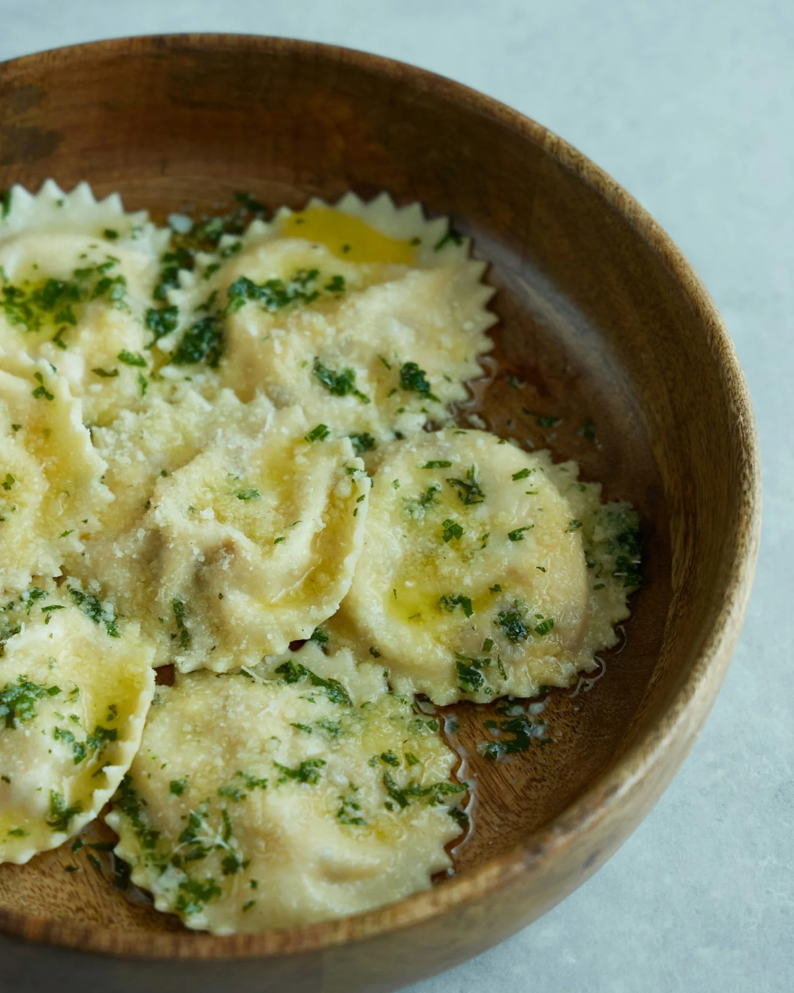 A bowl of duck ravioli with herb butter