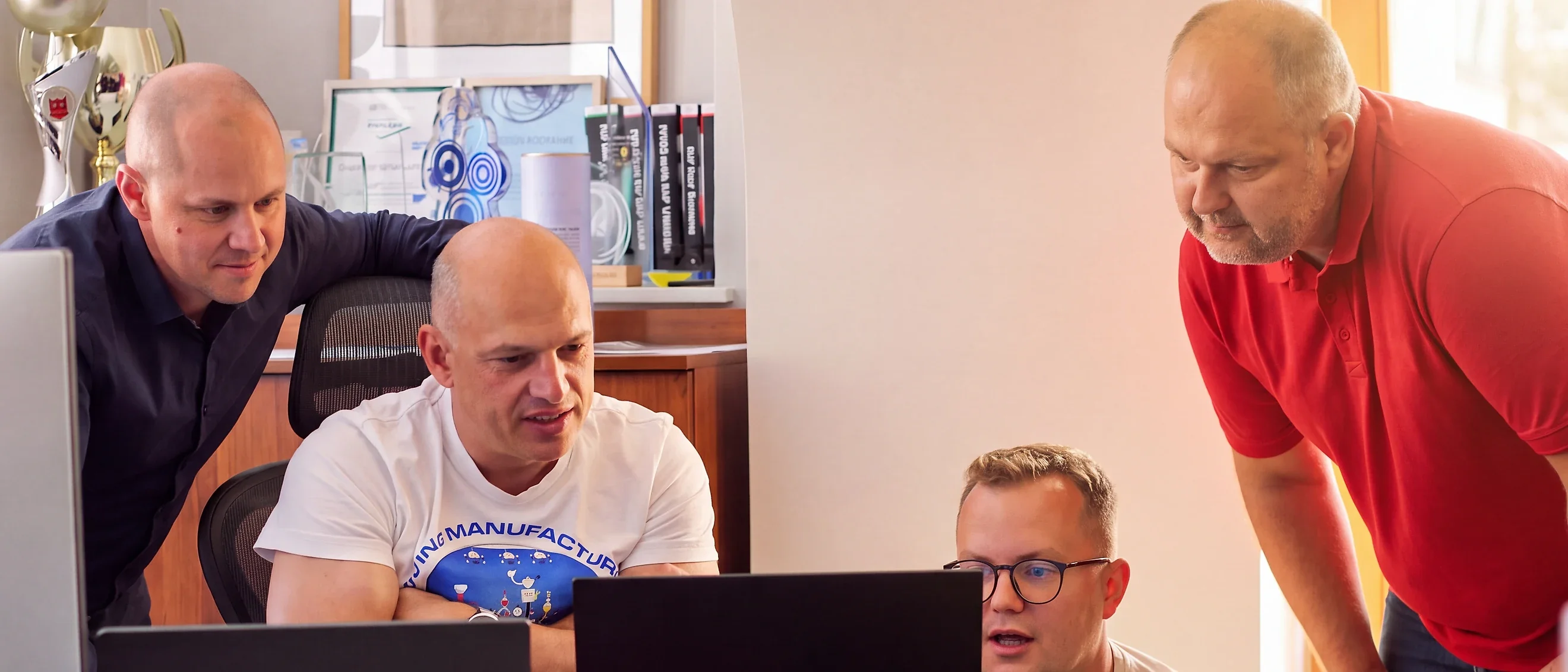 CompuTec team members working together at laptops in the office.