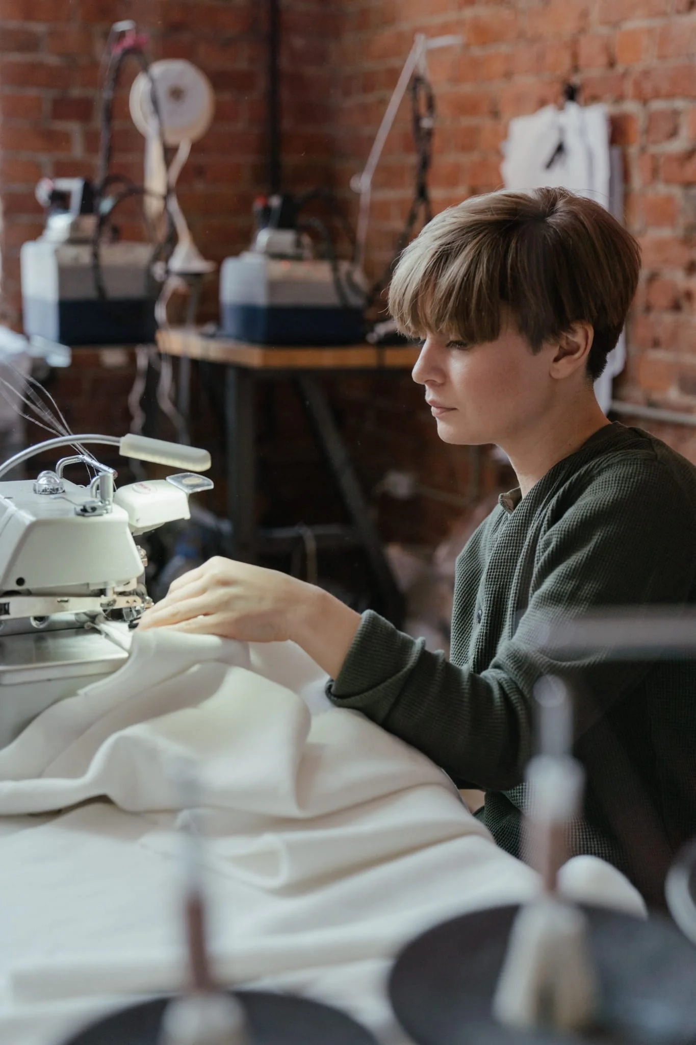 A worker sewing fabric on an industrial sewing machine