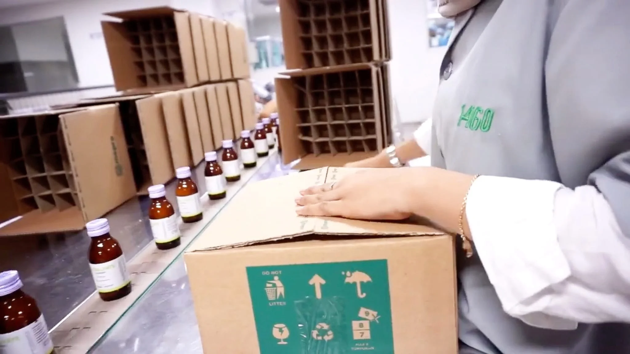 A Meprofarm employee packing bottles of medicine into branded cartons