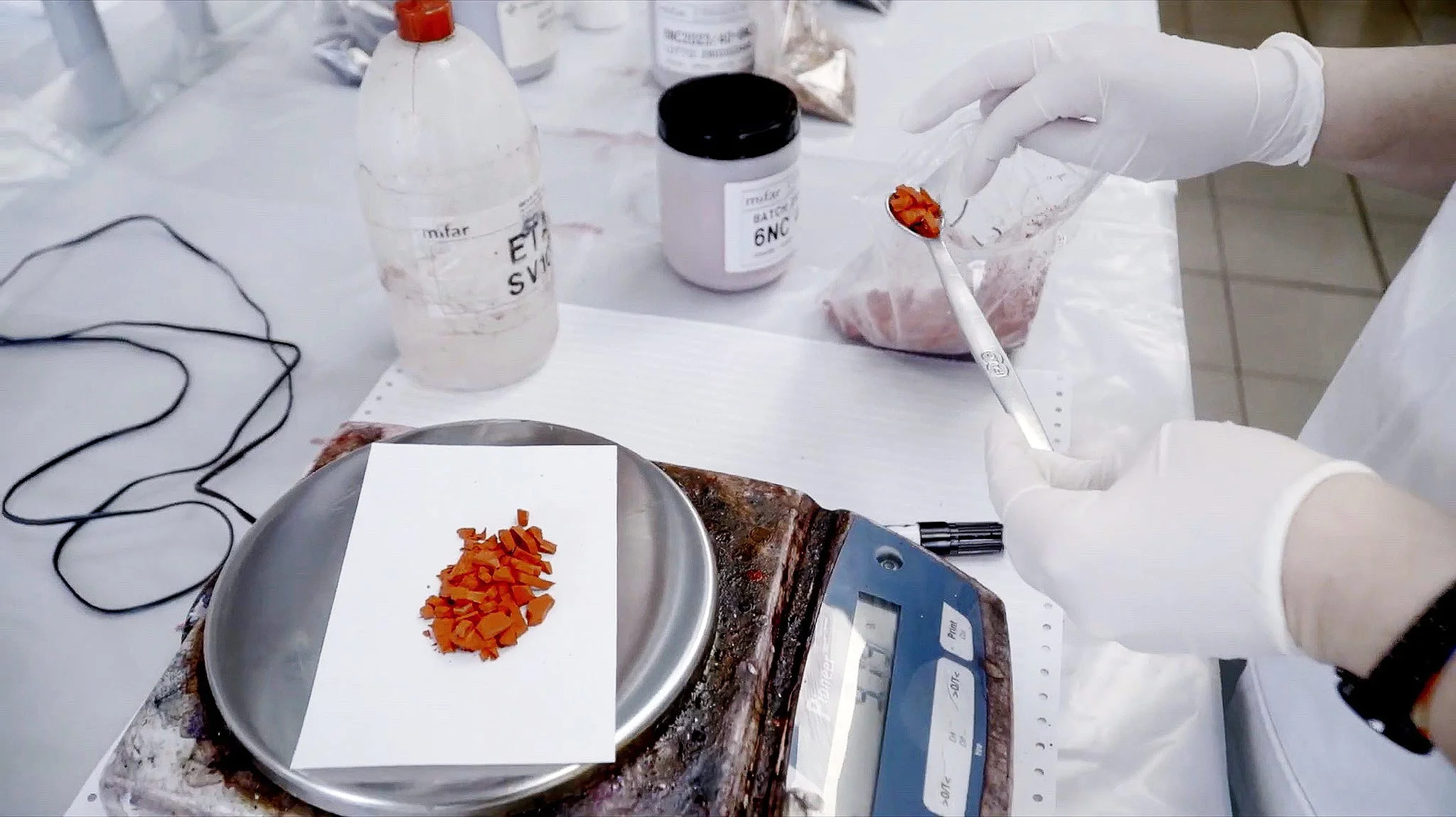 Orange pigment chips being measured on a scale