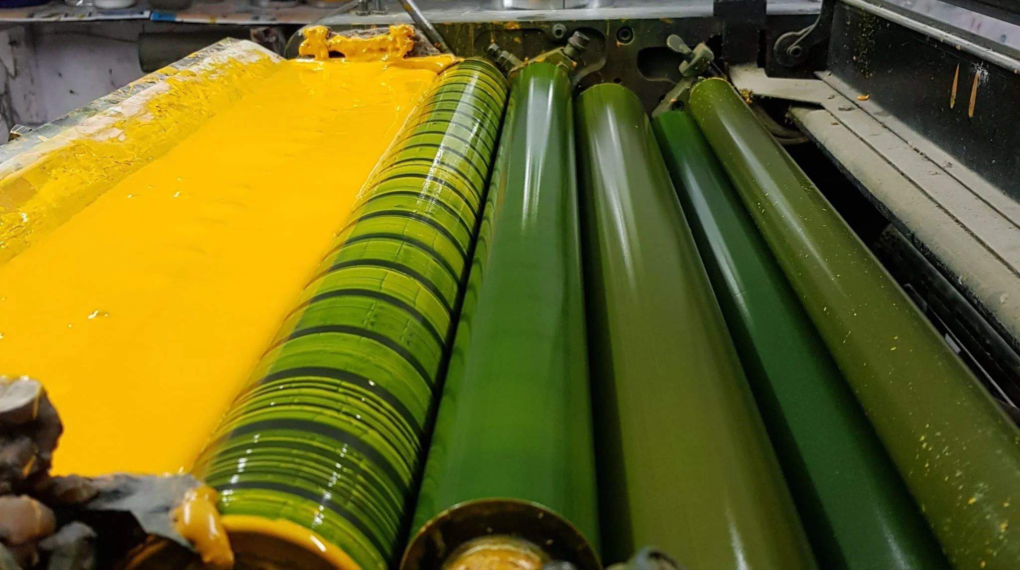 Yellow and green ink rollers on a printing press