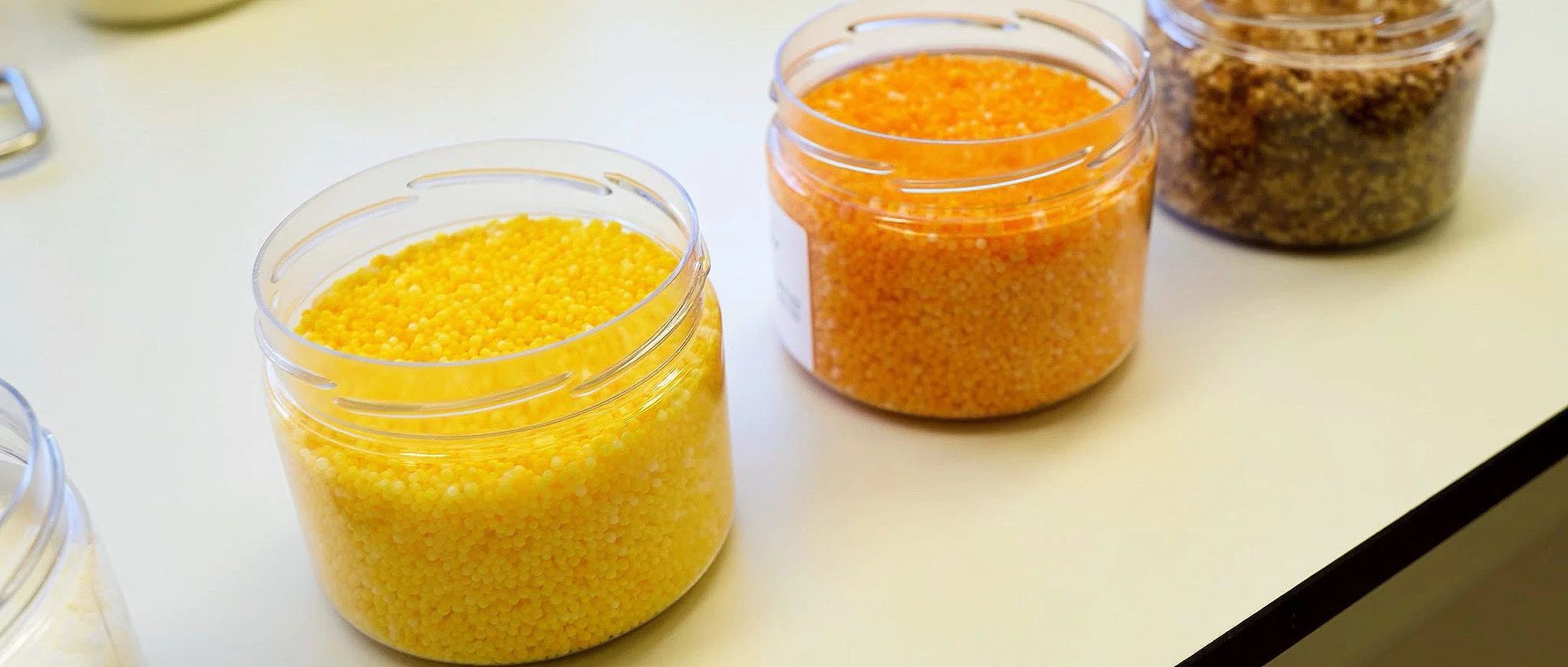 Jars of coated Victurea feed additive pellets at Palital Feed Additives