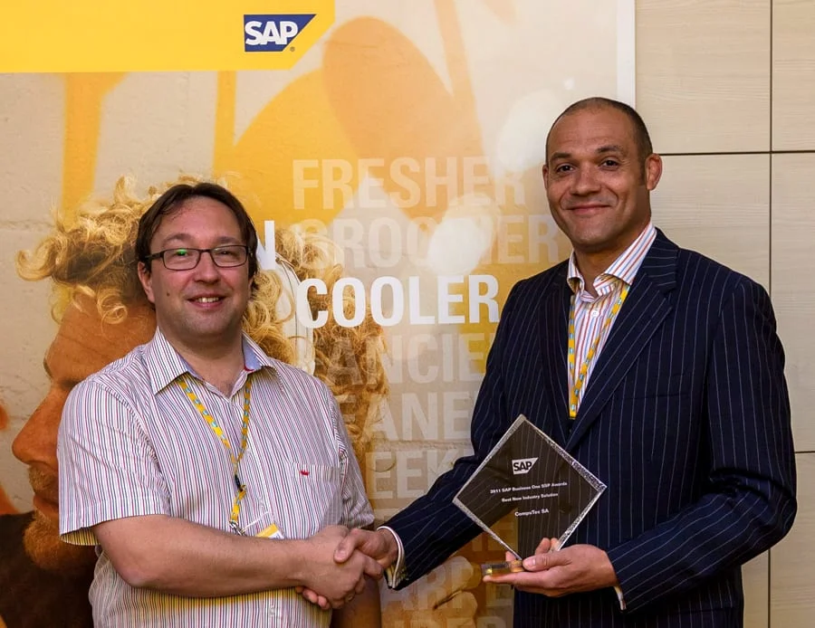 Two men shaking hands over the glass 2011 SAP Business One SSP Award for Best New Industry Solution, presented to CompuTec SA