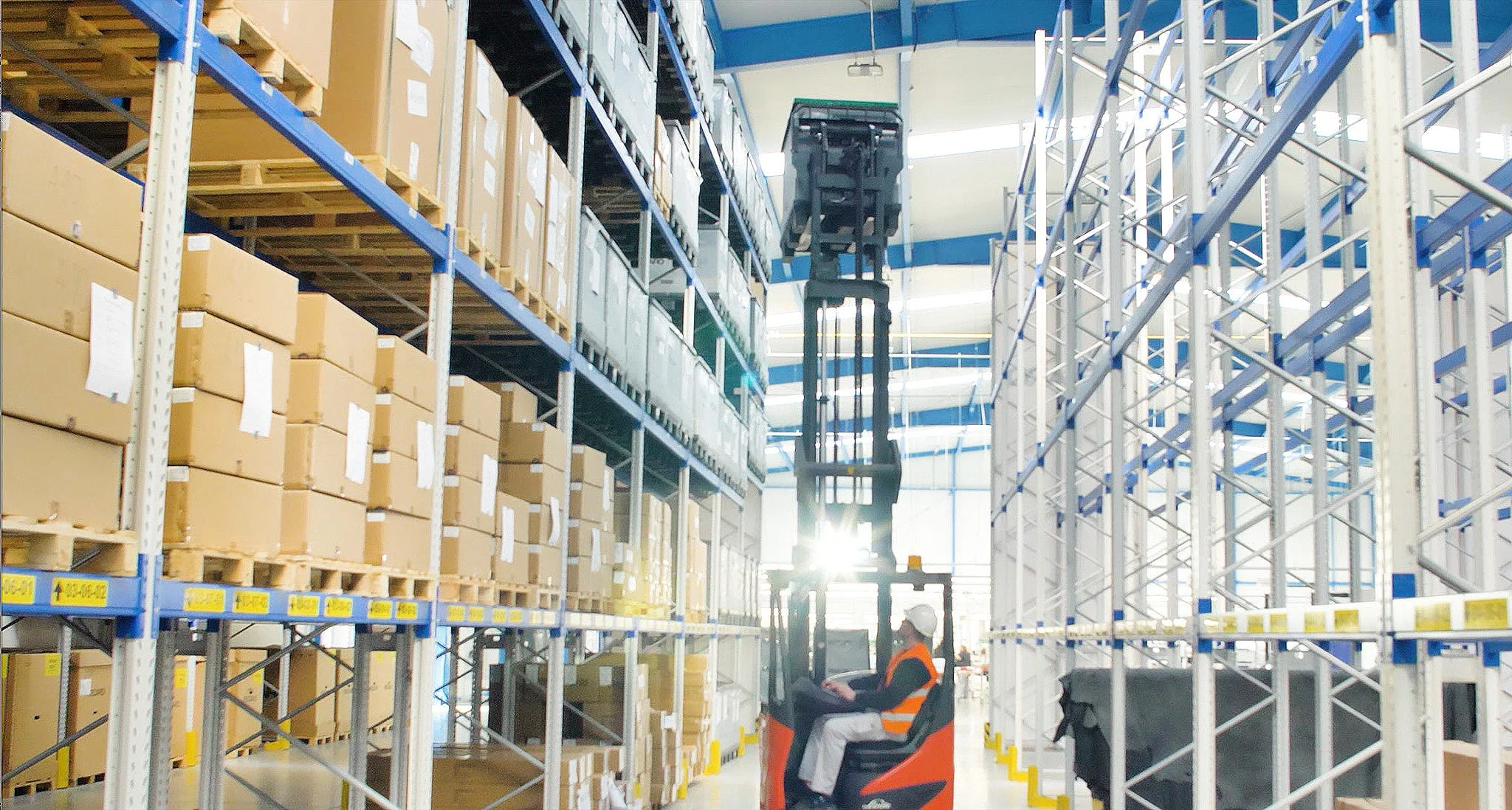 A forklift lifting a pallet high into warehouse racking at Schnug Logistic Group