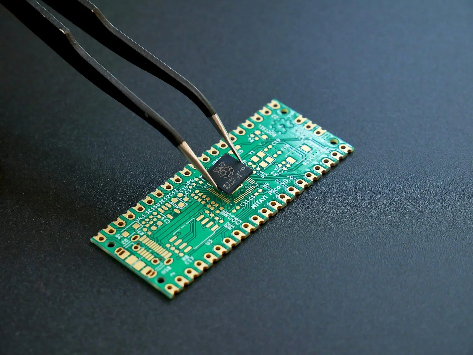 A component being placed onto a circuit board with tweezers