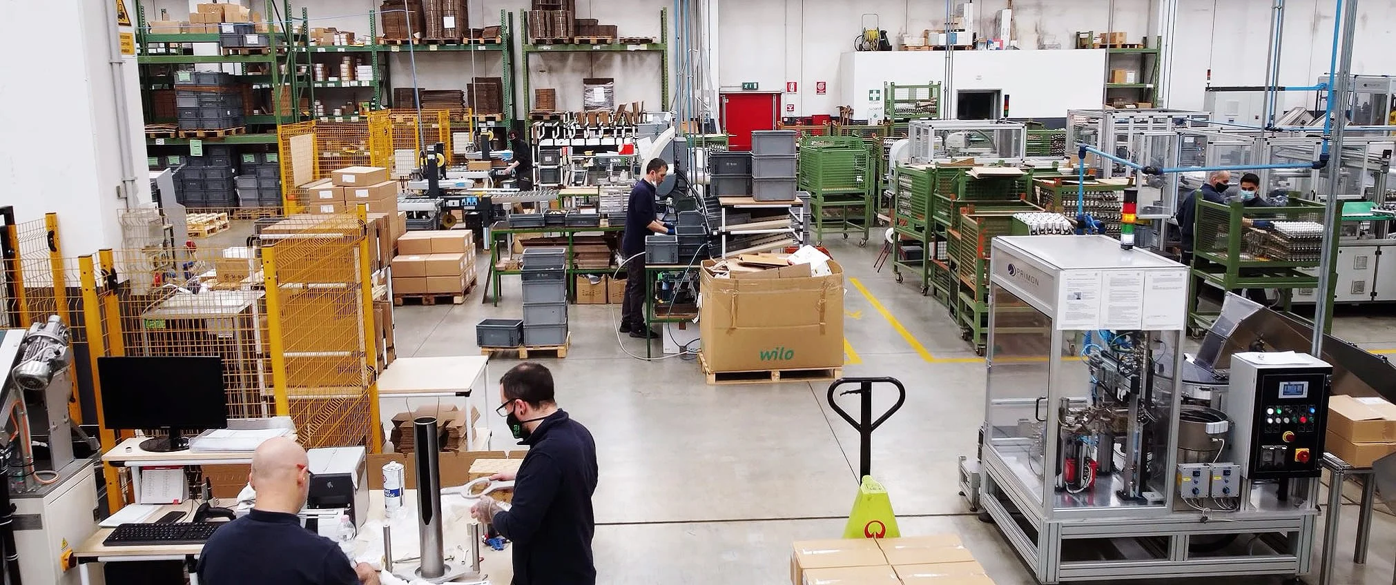 Wide view of TE-SA's factory floor, with employees working among production machinery and stock